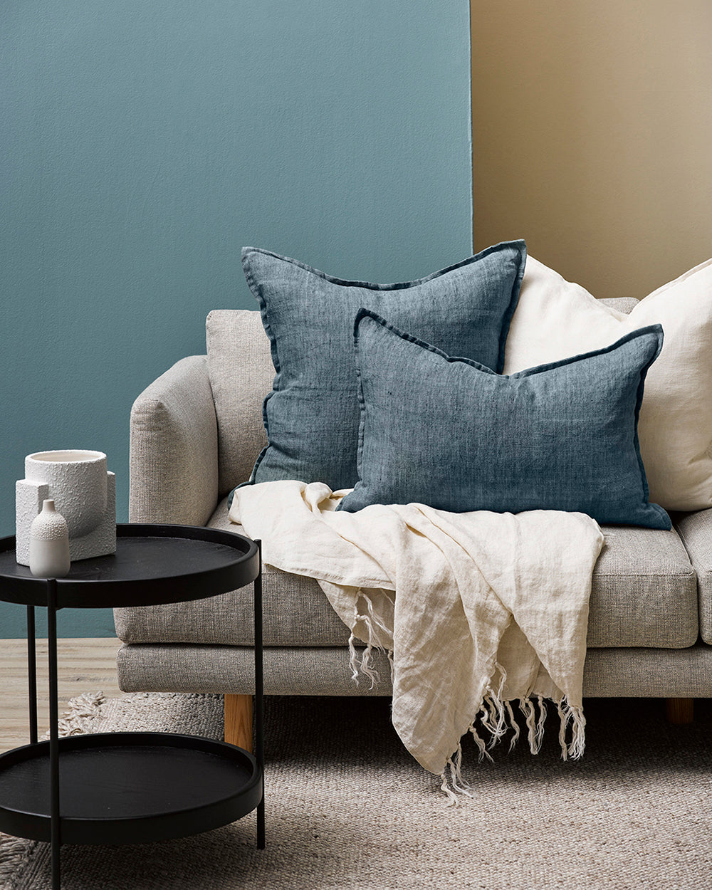 Indira cream linen throw on a grey sofa with blue flaxmill linen cushions 