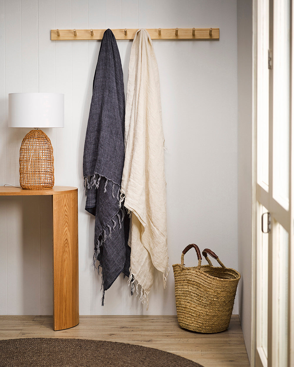 Indira linen throws in almond and french navy hanging from wooden pegs
