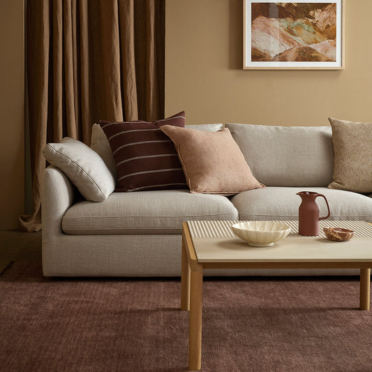Living room with a beige sofa, coffee table, and decorative pillows.