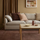 Living room with a beige sofa, coffee table, and decorative pillows.