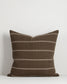 Brown pillow with white stripes on a white background