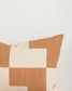 Patchwork pillow with brown and beige squares on a light background
