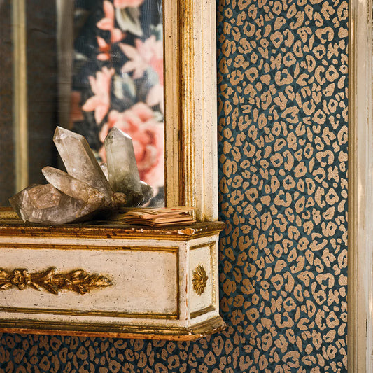 Decorative wall with leopard print wallpaper, crystal sculpture on a cabinet, and floral mirror reflection.