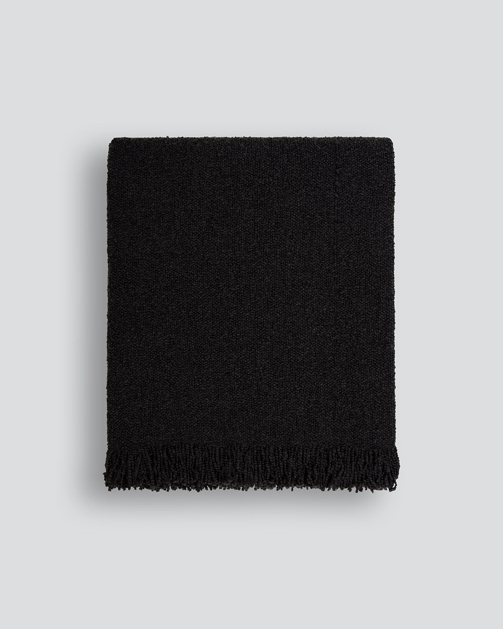 Black woven blanket on a light gray background