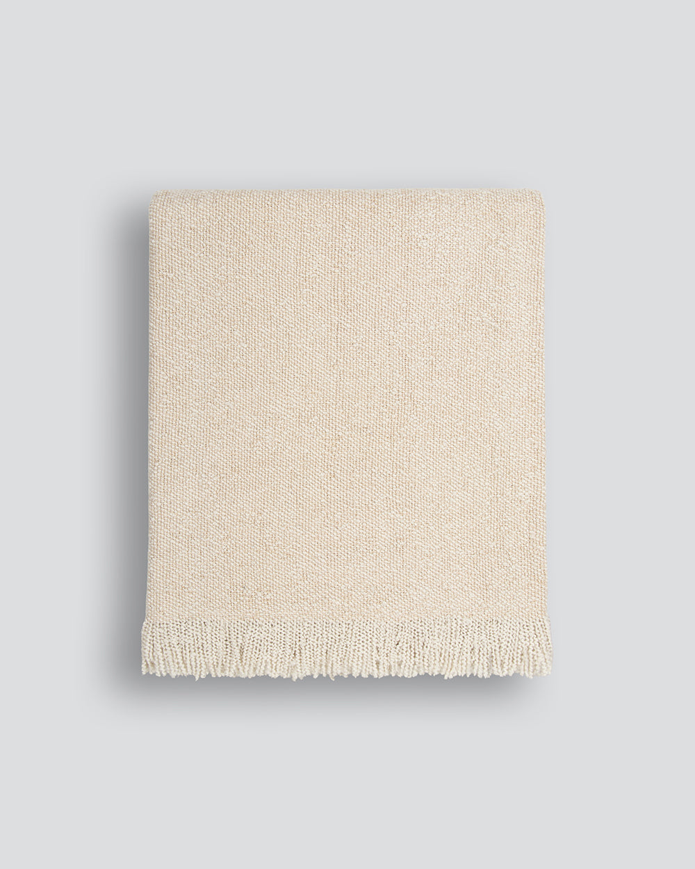 Beige woven blanket on a light gray background