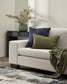 White sofa with green and blue pillows and a plant in a room.