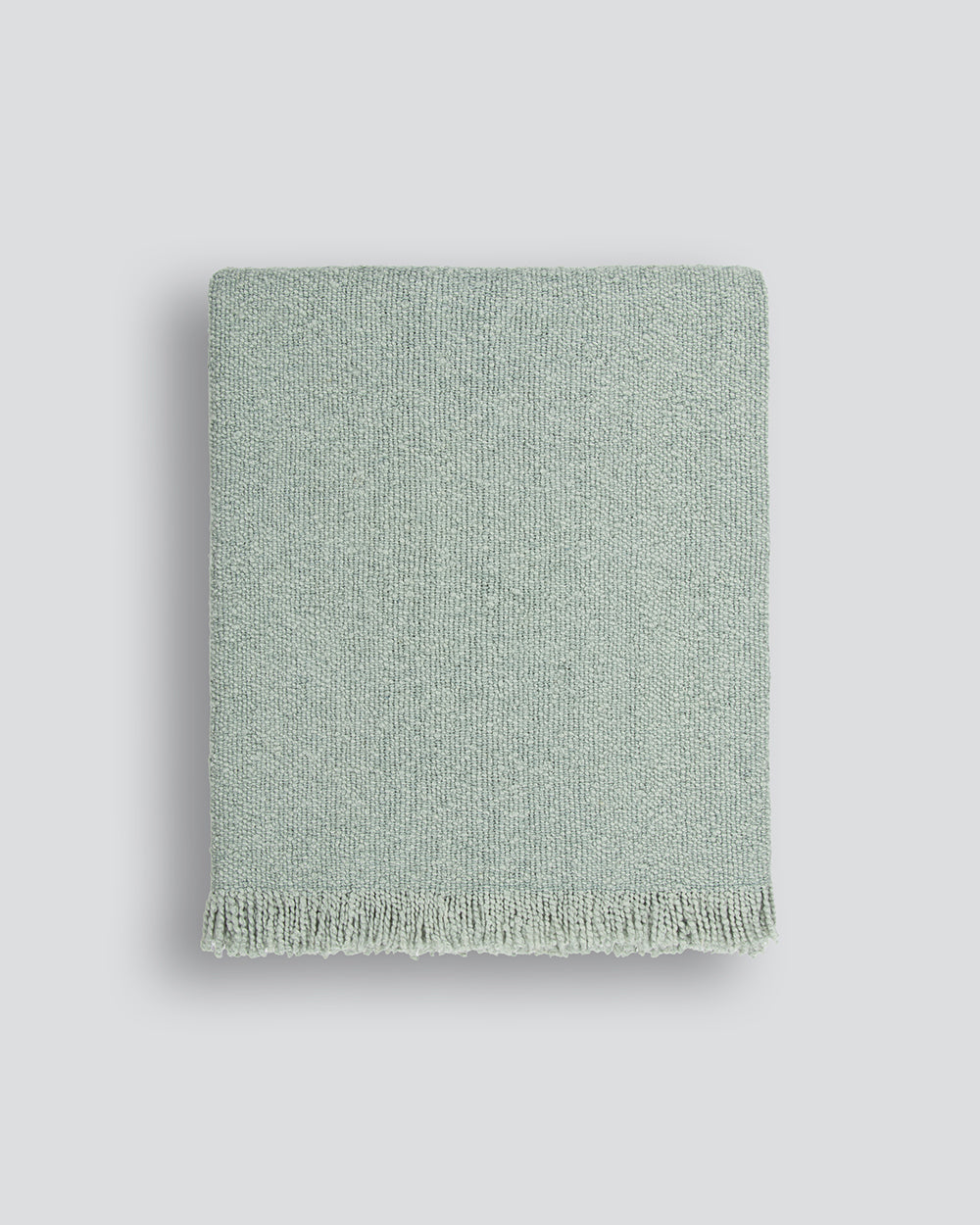 Green textured blanket on a light gray background