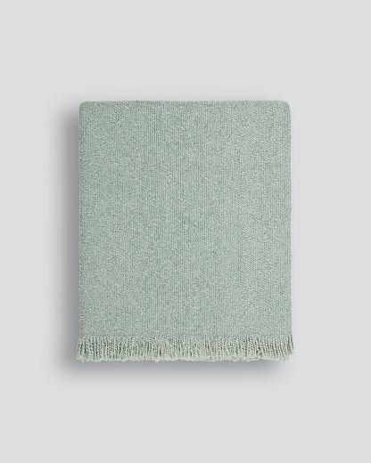 Green textured blanket on a light gray background