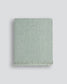 Green textured blanket on a light gray background