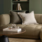Beige sofa with decorative pillows in a living room setting.