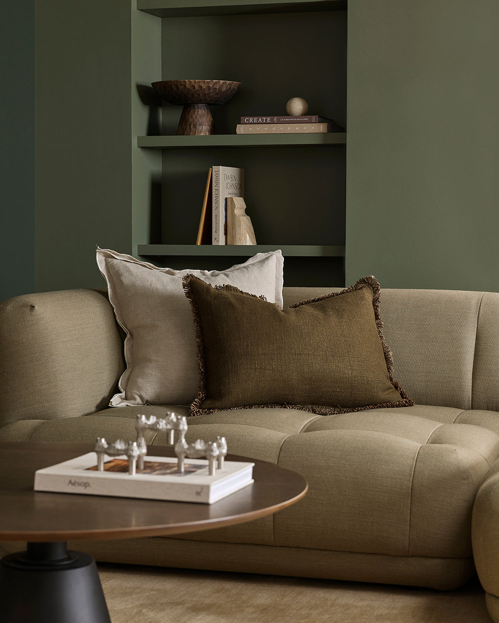 beige sofa with decorative pillows in a living room setting.