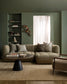 Modern living room with a beige sectional sofa, coffee table, and decorative elements.