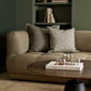 Beige sofa with decorative pillows in a living room setting.