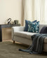 Living room with a beige sofa, decorative pillows, and a side table.