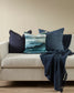 Beige sofa with navy and patterned throw pillows against a beige wall