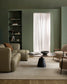 Modern living room with beige sofa, armchair, and round coffee table.