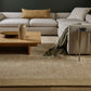 Modern living room with a sectional sofa, coffee table, and abstract art on the wall.