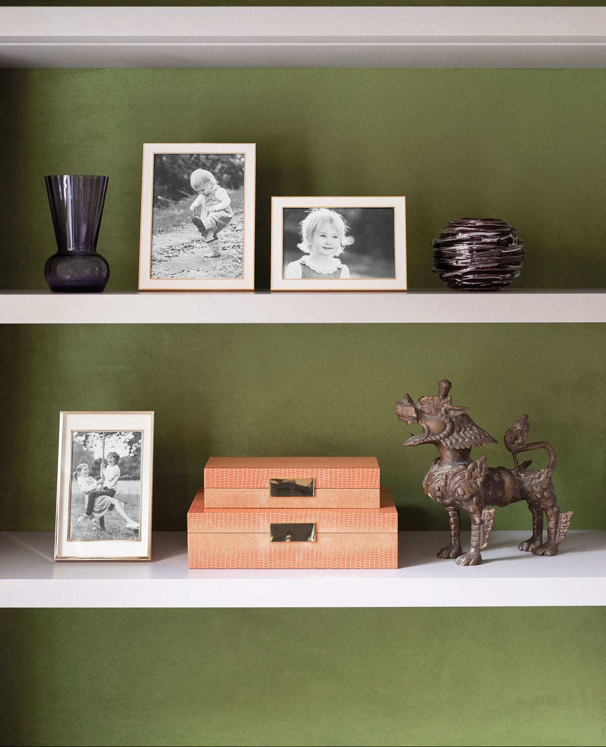 Shelving unit with decorative items against a green wall, featuring the brand 'Addison Ross London'.