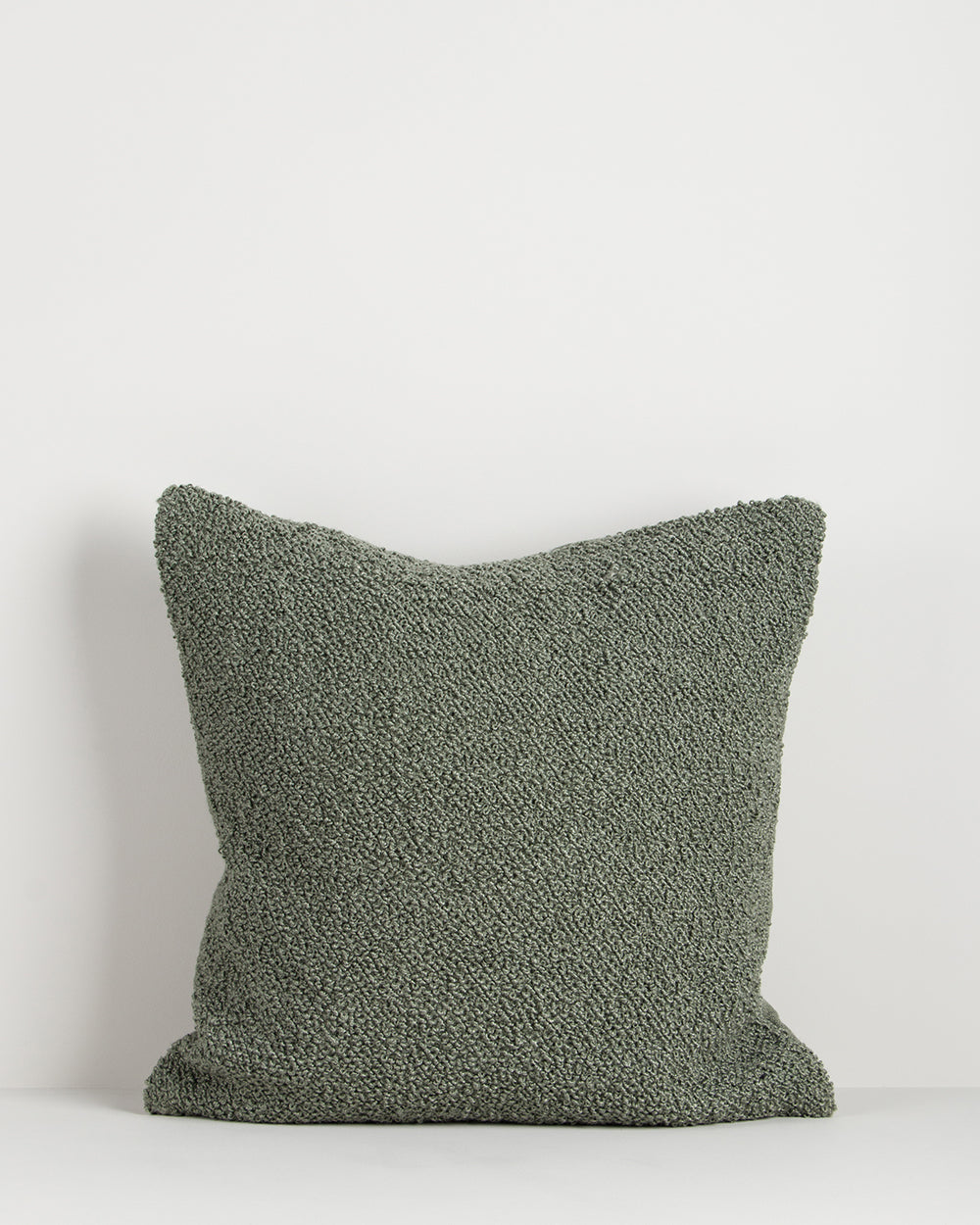 Textured green pillow on a white background