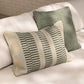 Two patterned pillows on a light-colored sofa with a neutral background
