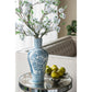 Decorative blue and white vase with floral arrangement on a table.