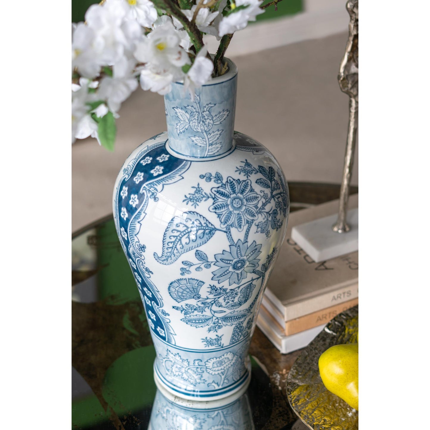 Decorative blue and white vase with floral patterns on a table.