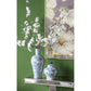 Decorative vases with floral design on a green wall with a floral painting.