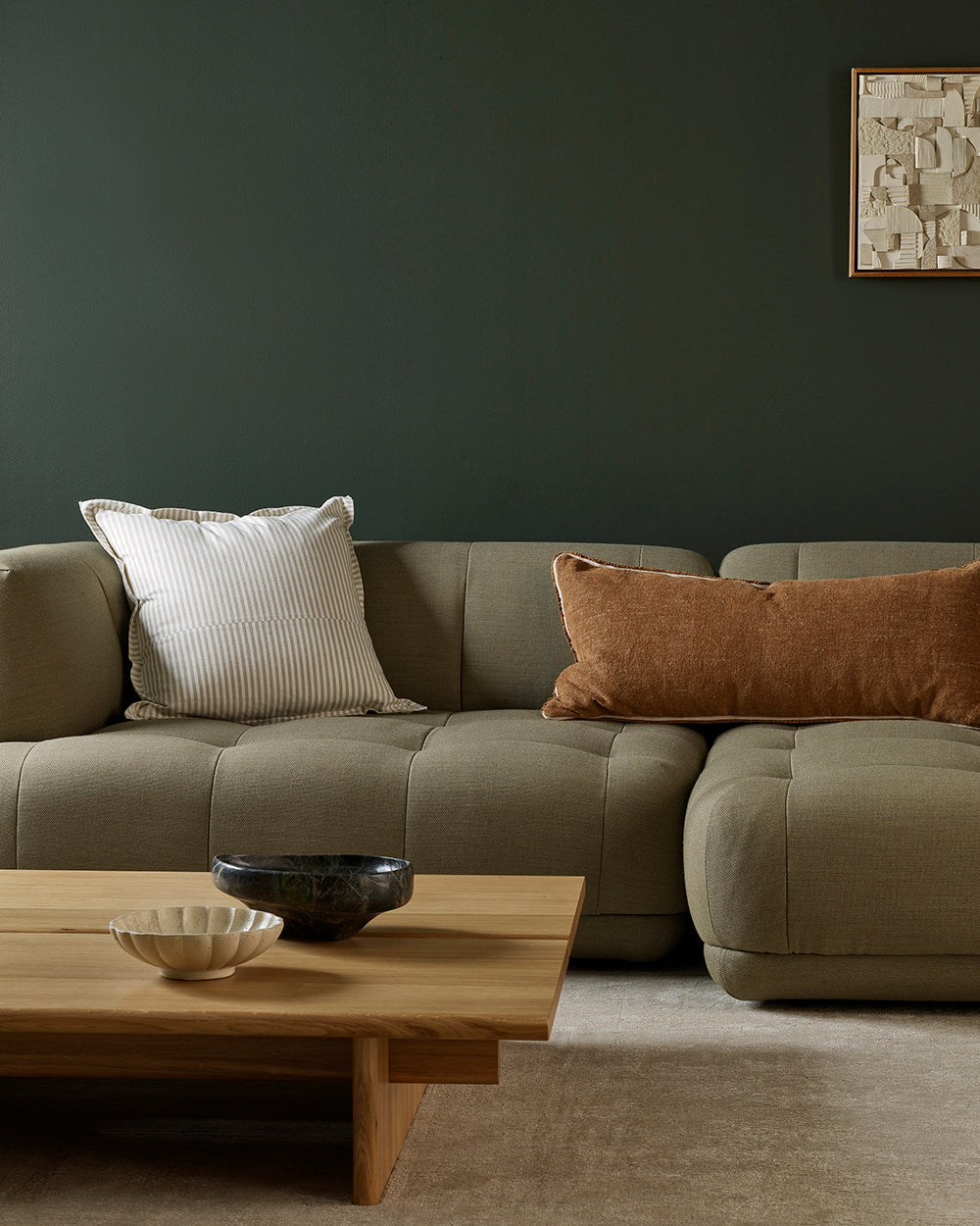Modern living room with a beige sectional sofa, wooden coffee table, and decorative pillows.