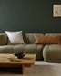Modern living room with a beige sectional sofa, wooden coffee table, and decorative pillows.