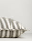 Striped pillow with gray and white stripes on a light gray background
