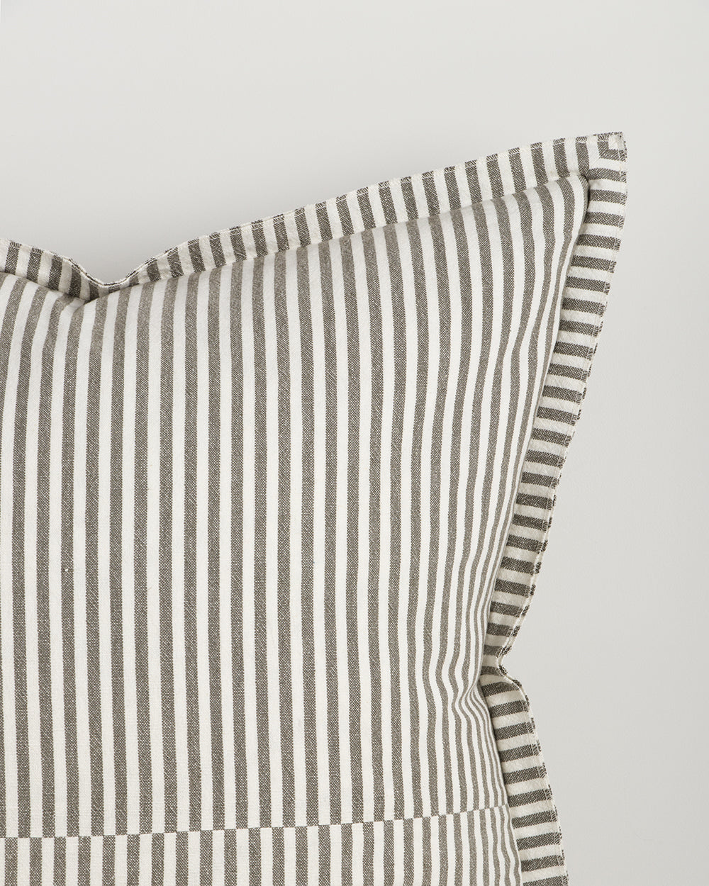 Striped pillowcase with green and white stripes on a light gray background