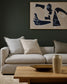 Modern living room with a gray sofa, abstract art, and wooden coffee table.
