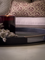 Candle and lavender on a shagreen tray with a patterned pillow in the background