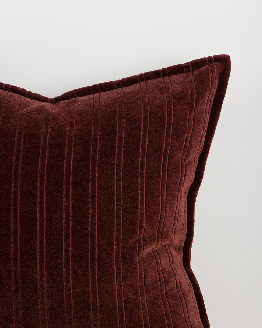 Close-up of a burgundy textured pillow on a white background