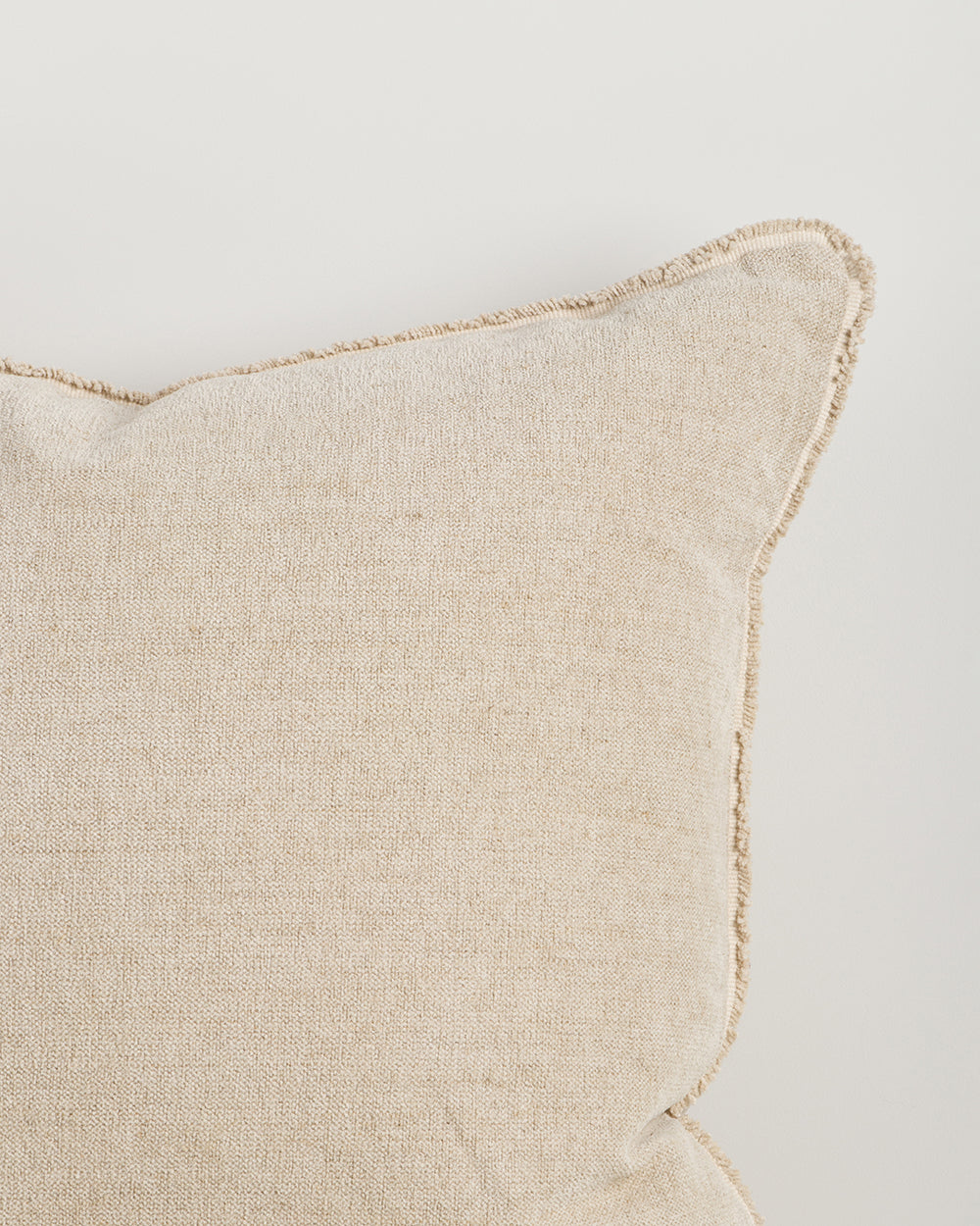 Beige pillow with textured edge on a light gray background