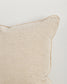 Beige pillow with textured edge on a light gray background