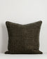 Dark brown textured pillow on a light gray background