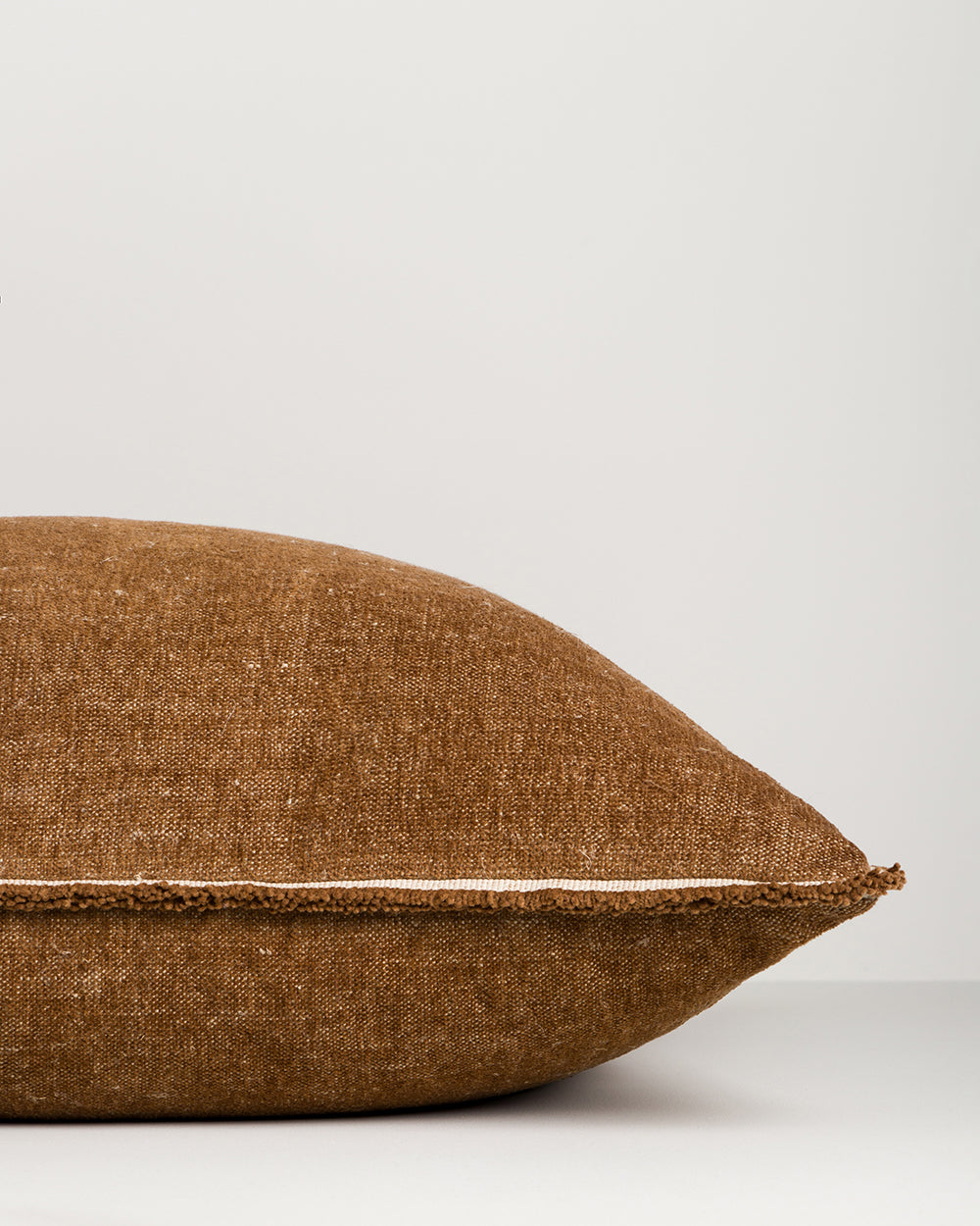 Brown textured pillow on a light gray background