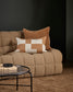 Beige sofa with decorative pillows in a dark room