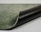 Roll of green and black textured carpet on a white background