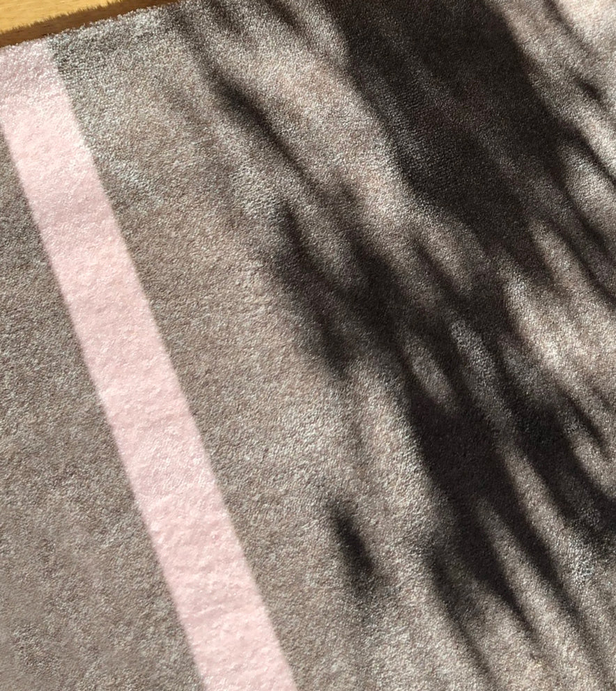 Close-up of a textured fabric with horizontal stripes in gray and pink.