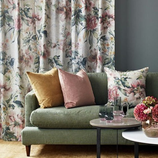 Leila Linen Fabric James Dunlop pink green and grey large floral print on curtains and cushion on green sofa