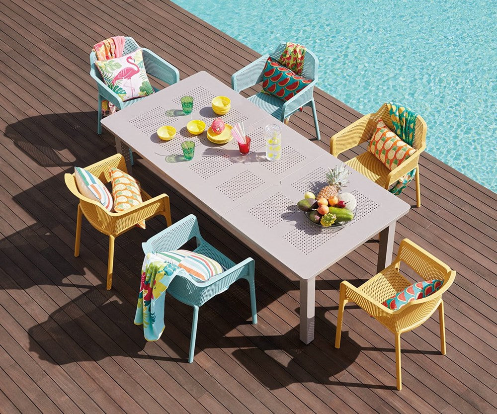 net outdoor chair chairs in mustard and spearmint around a table by the pool