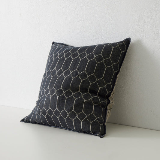 vaucluse cushion in black with geometric pattern in ivory leaning against wall