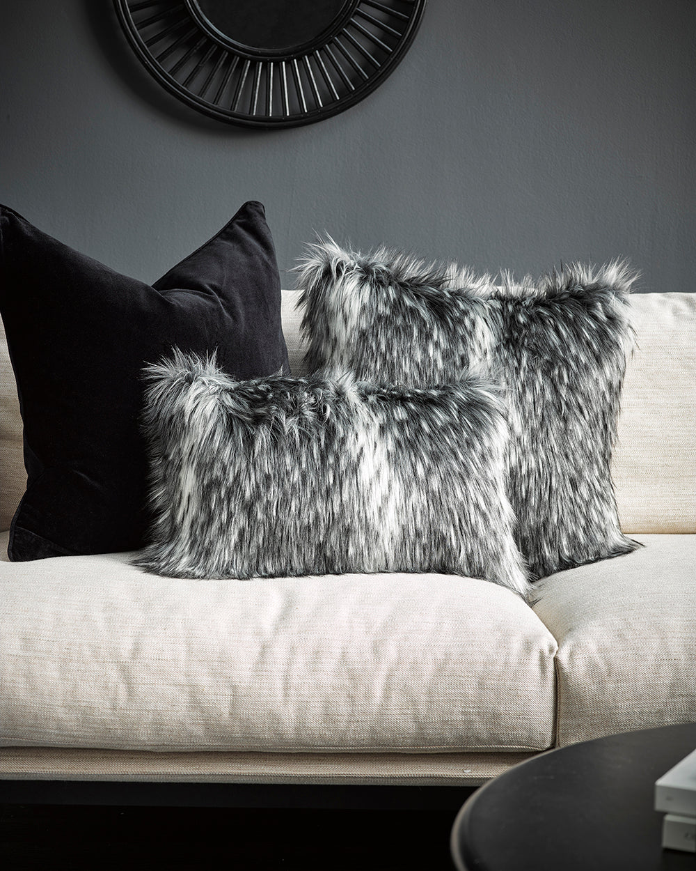 Alaskan wolf imitation fur cushions on white sofa and grey walls