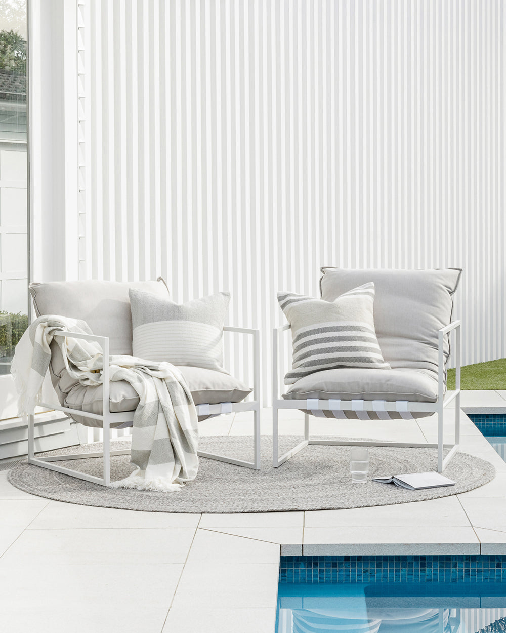 Corbett outdoor cushion on two patio chairs by the pool