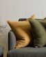 nutmeg and olive Flaxmill linen cushions on a dark grey sofa