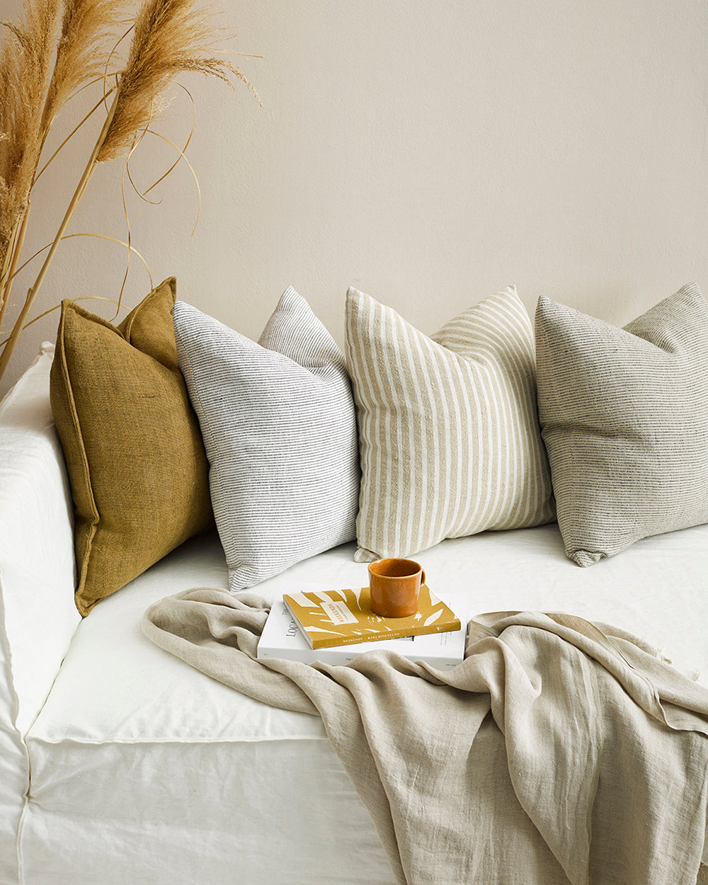 Flaxmill linen cushions in fenugreek and white matching cushions on an ivory sofa