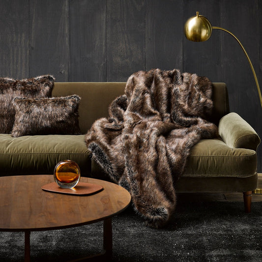 Imitation faux fur throw in Husky on green velvet sofa with gold light and wooden cofee table