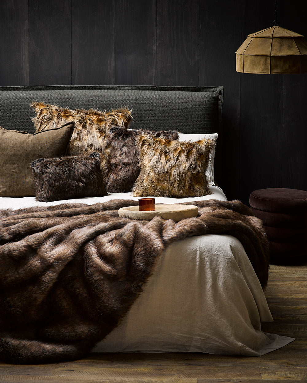 Imitation faux fur throw in Husky on bed with other fur cushions in a lifestyle shot